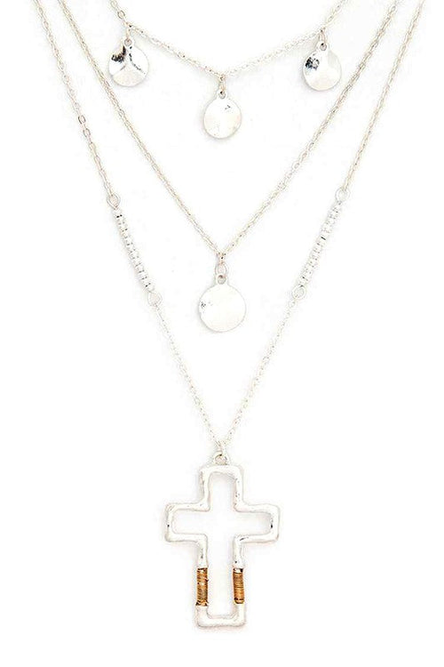 Layered silver necklaces with a cross pendant on a white background