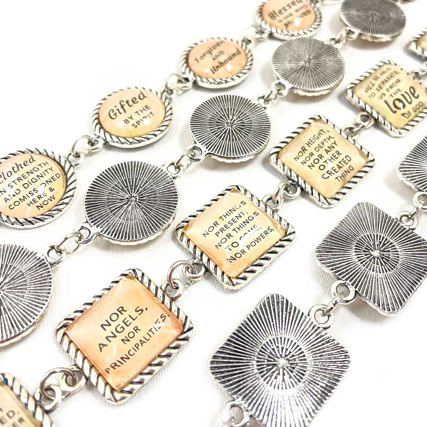 Bracelet with various engraved charms on a white background