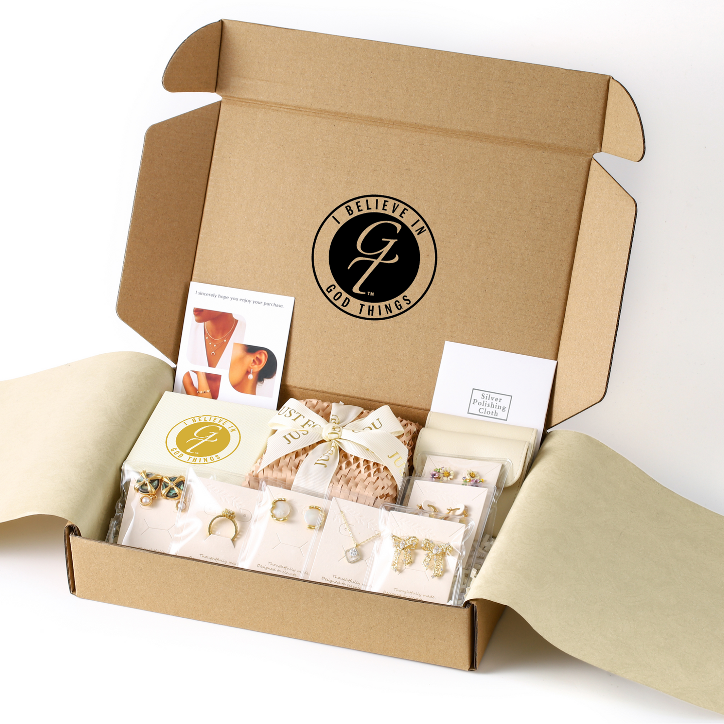 Open cardboard box with jewelry and packaging materials, featuring a visible brand logo.
