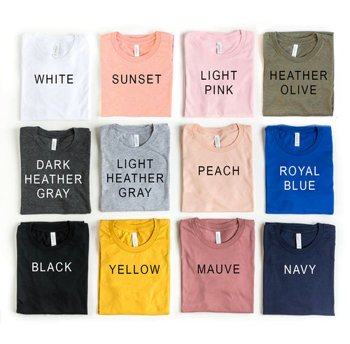 Collection of folded shirts in various colors with labels on a white background