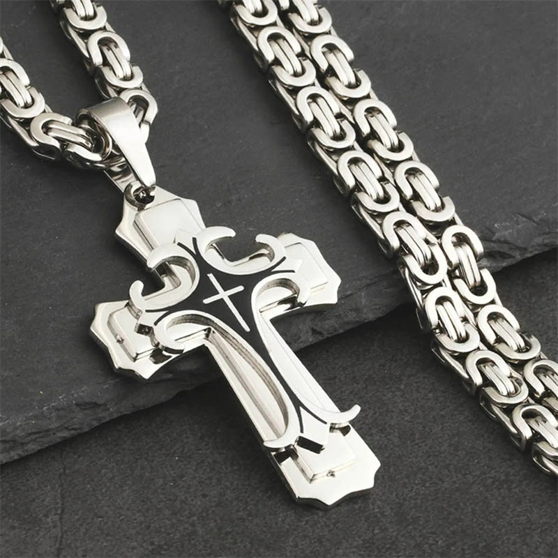 Silver cross pendant with chain on a dark surface