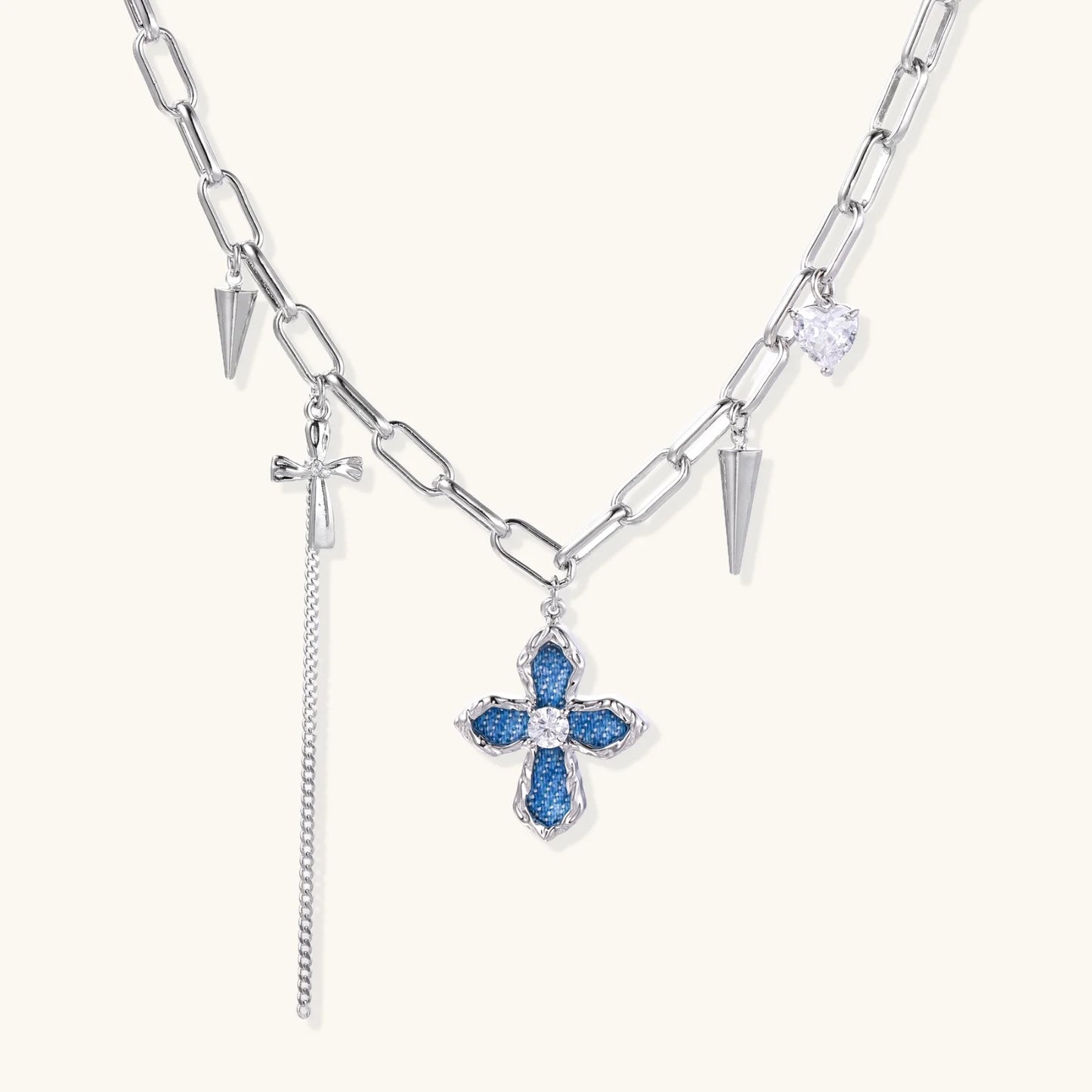 White gold plated chain necklace with blue textured cross pendant, spike charms, and mini cross detail on beige background,  a perfect envouragement jewelry gift for women 