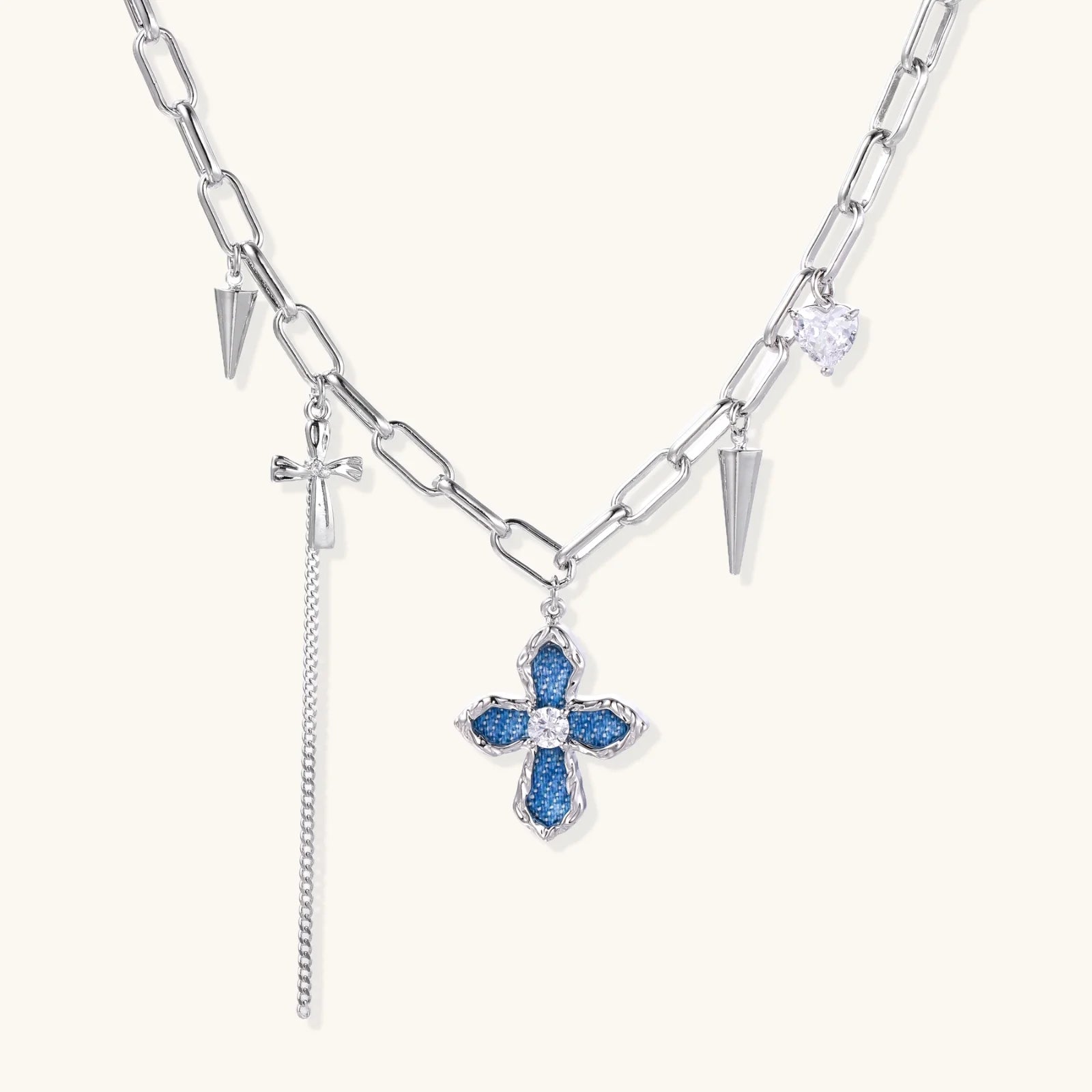 White gold plated chain necklace with blue textured cross pendant, spike charms, and mini cross detail on beige background,  a perfect envouragement jewelry gift for women 