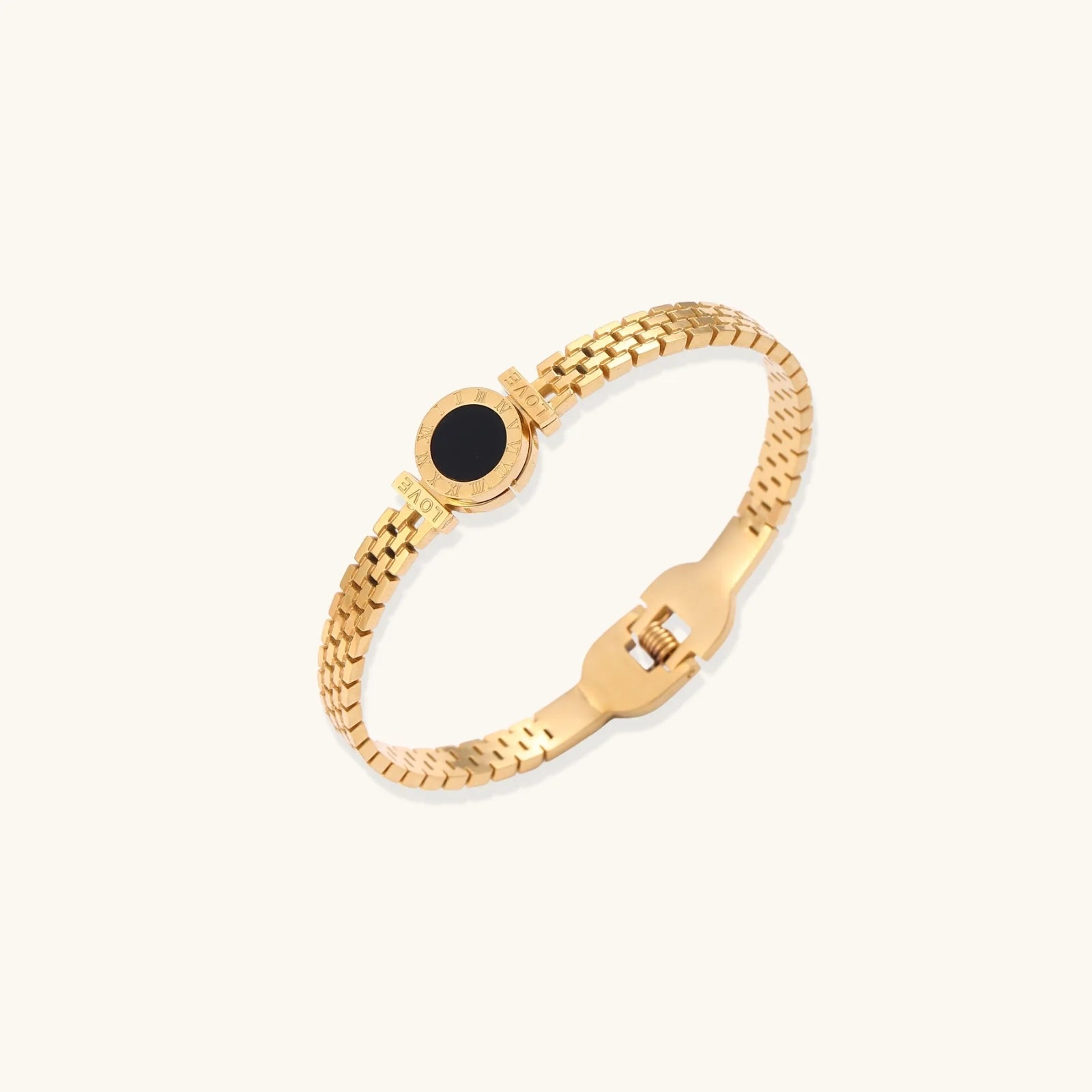 Gold mesh bracelet with circular black mother of pearl medallion featuring Roman numeral engravings and hinged clasp