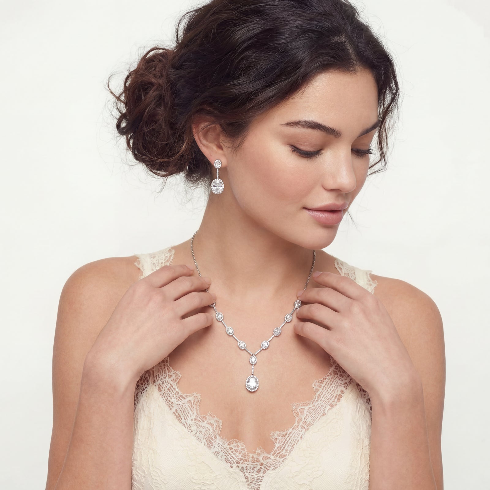 woman wearing Elegant white gold plated jewelry set with oval cubic zirconia stones in halo settings, featuring Y-necklace and drop earrings.