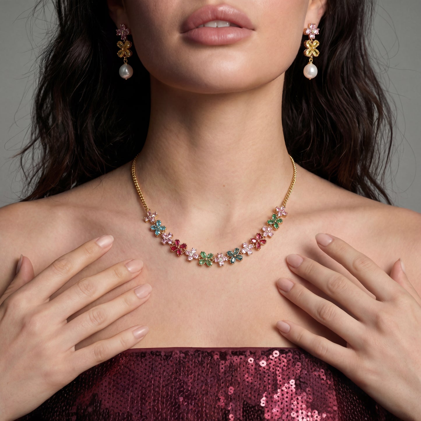 woman wearing Gold-plated jewelry set with pink, turquoise and red flower-shaped cubic zirconia stones, featuring necklace, earrings and bracelet.