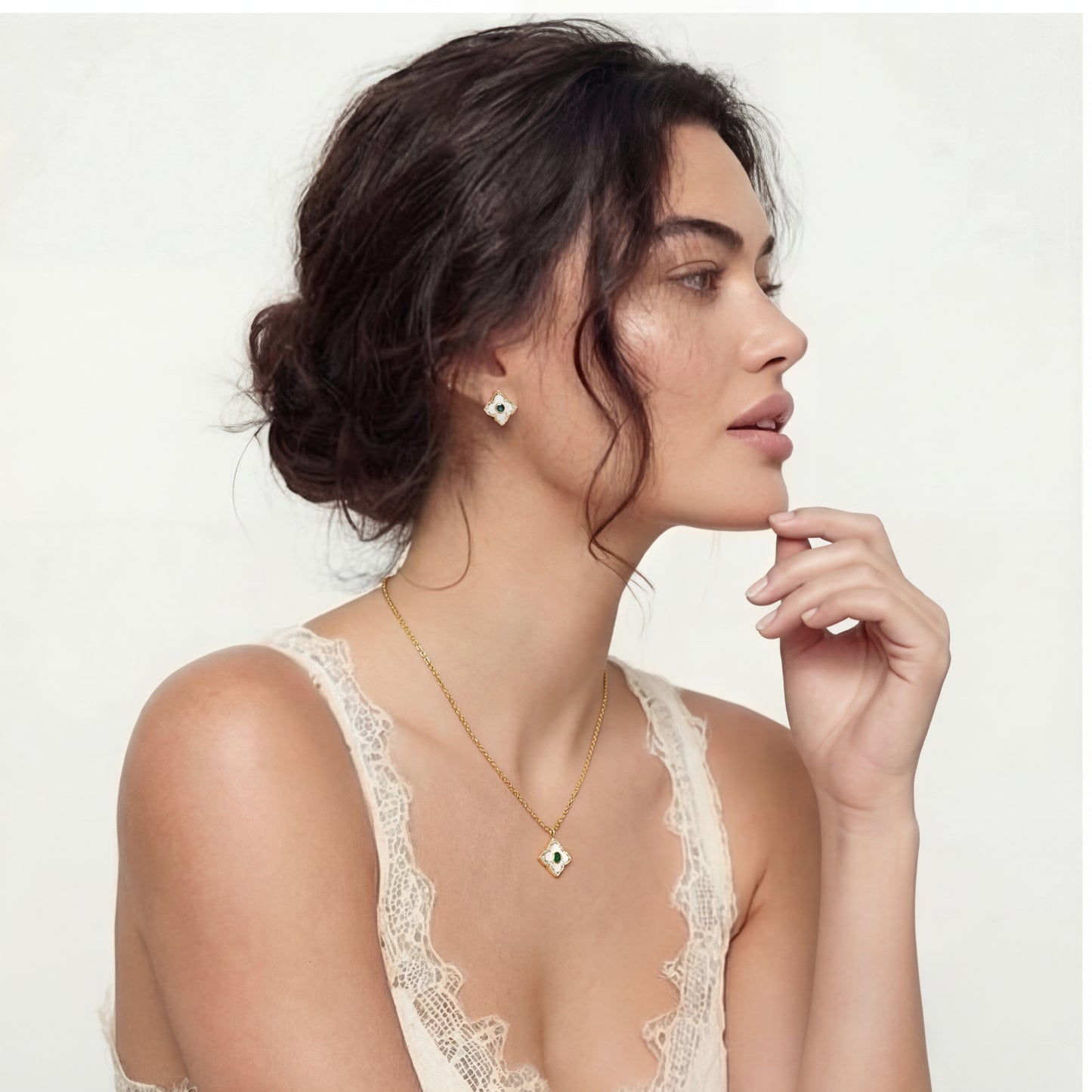 woman wearing Gold-plated jewelry set with diamond-shaped pendants featuring white centers, green stones, and sparkling zirconia borders