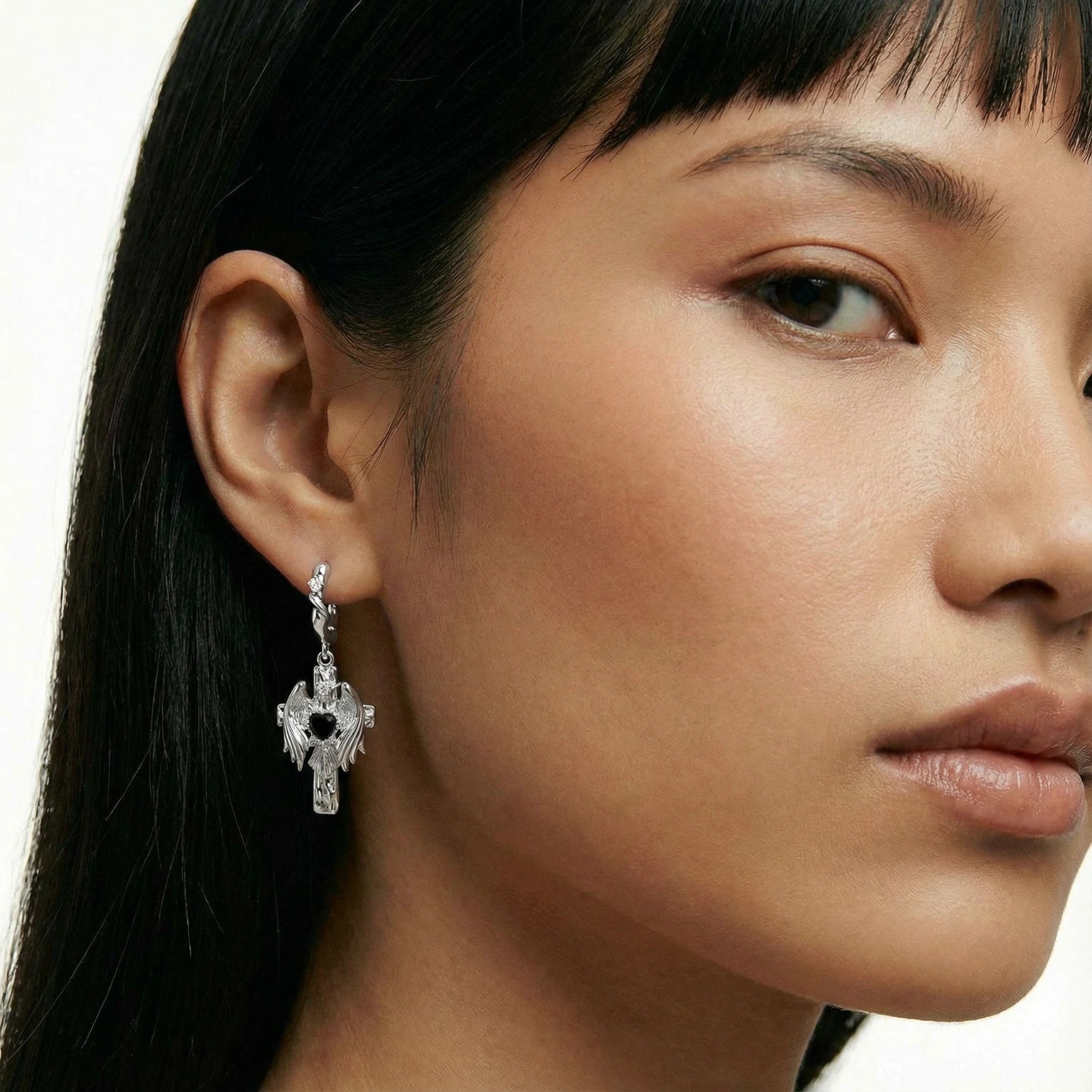 Close-up of a woman wearing a silver earring with a white background