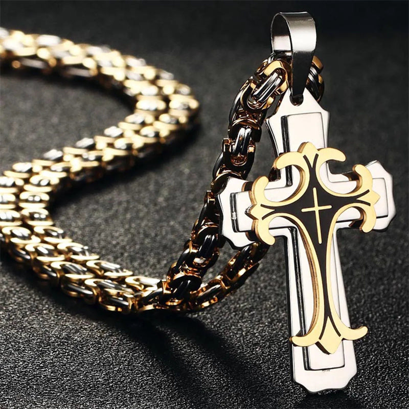 Gold and silver cross pendant on a chain against a dark background