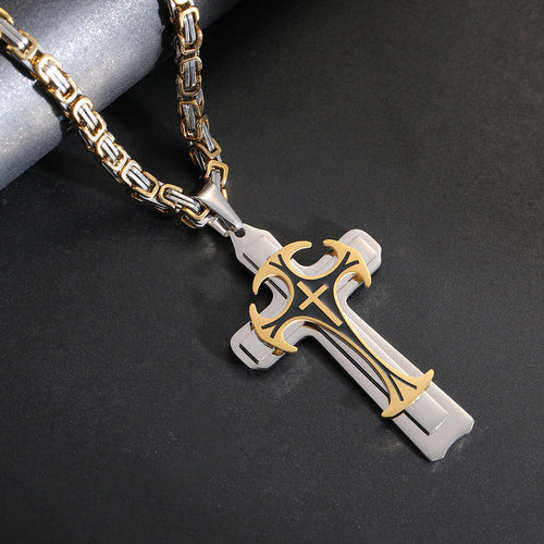 Gold and silver cross pendant on a chain against a dark background