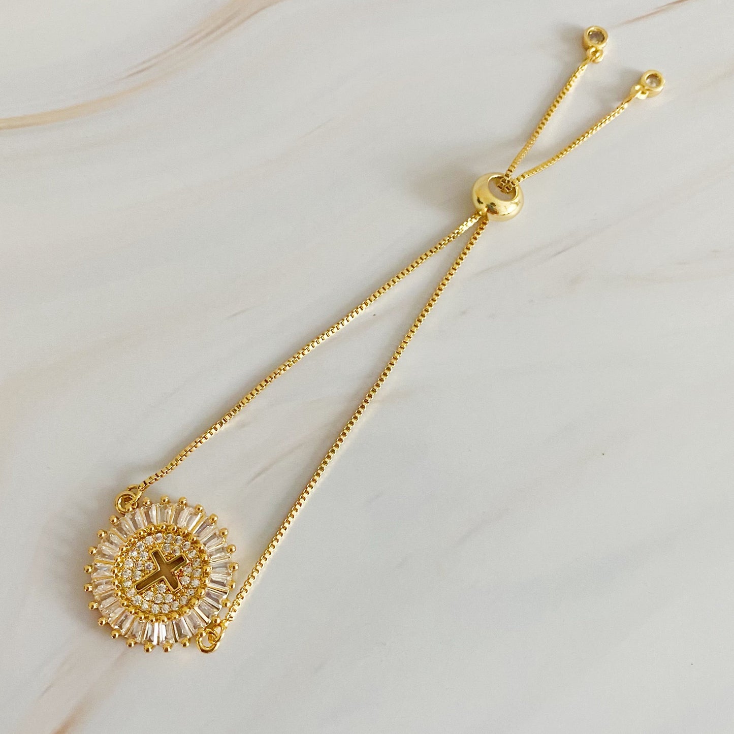Gold necklace with a decorative pendant on a light background