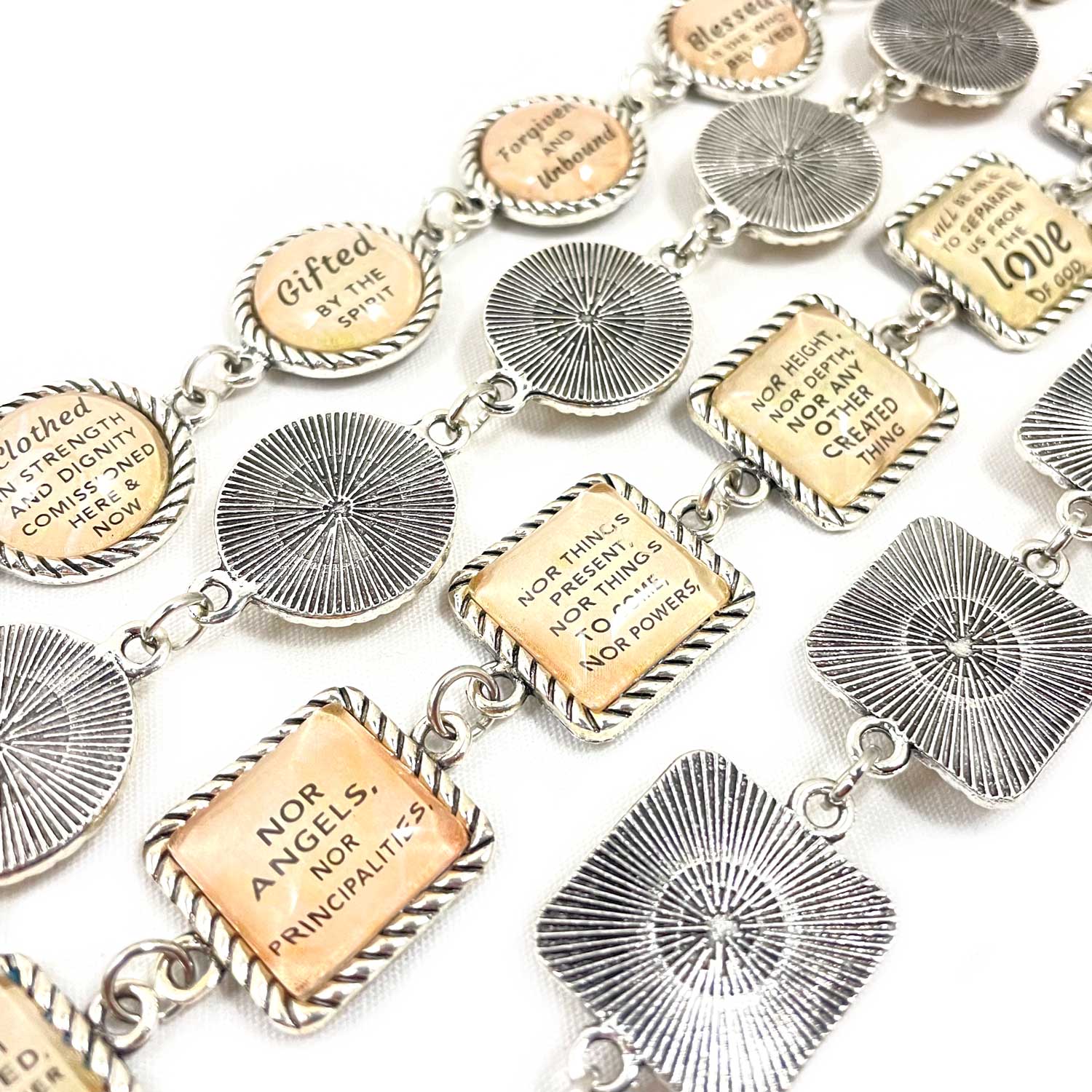 Bracelet with various engraved charms on a white background