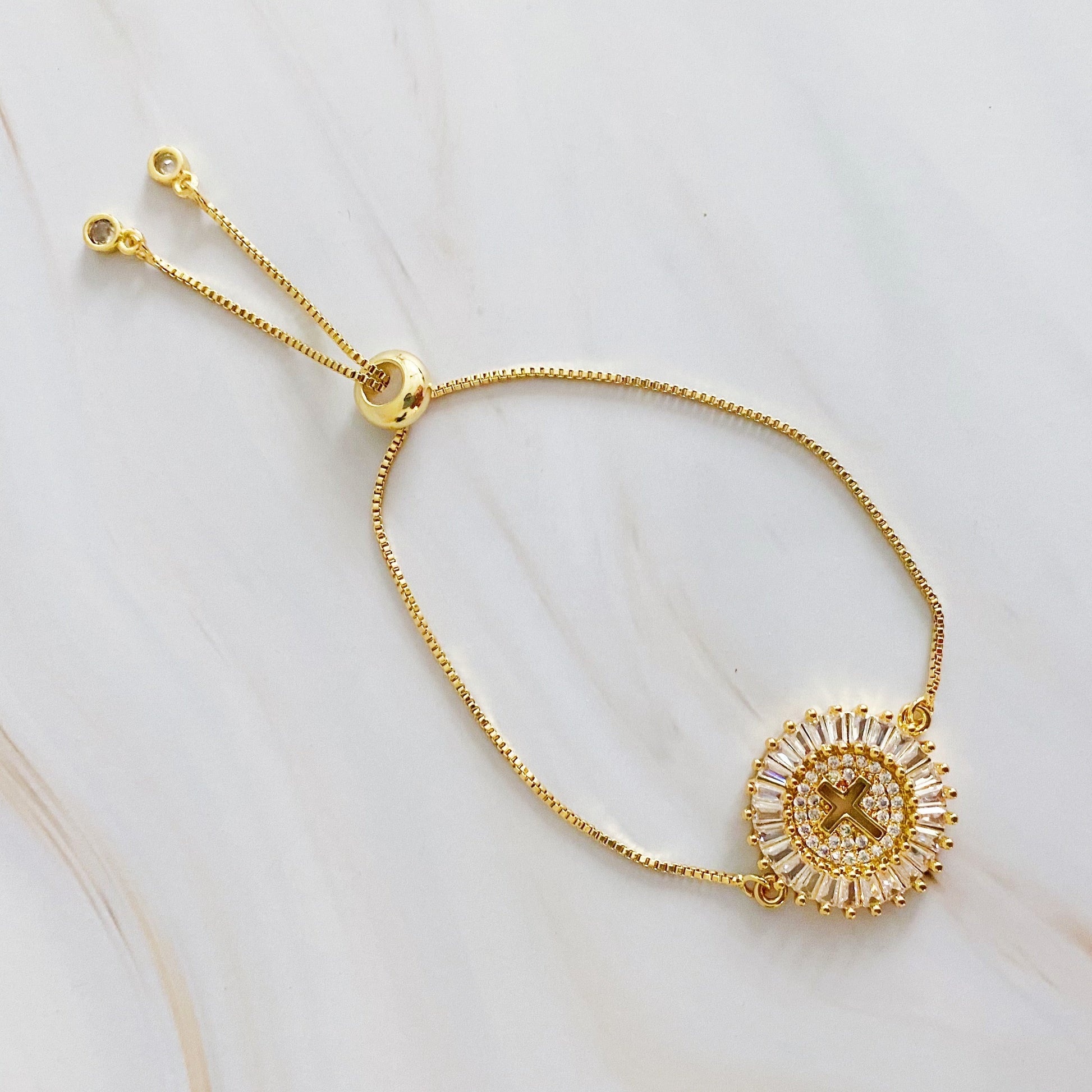 Gold bracelet with a circular design on a light background