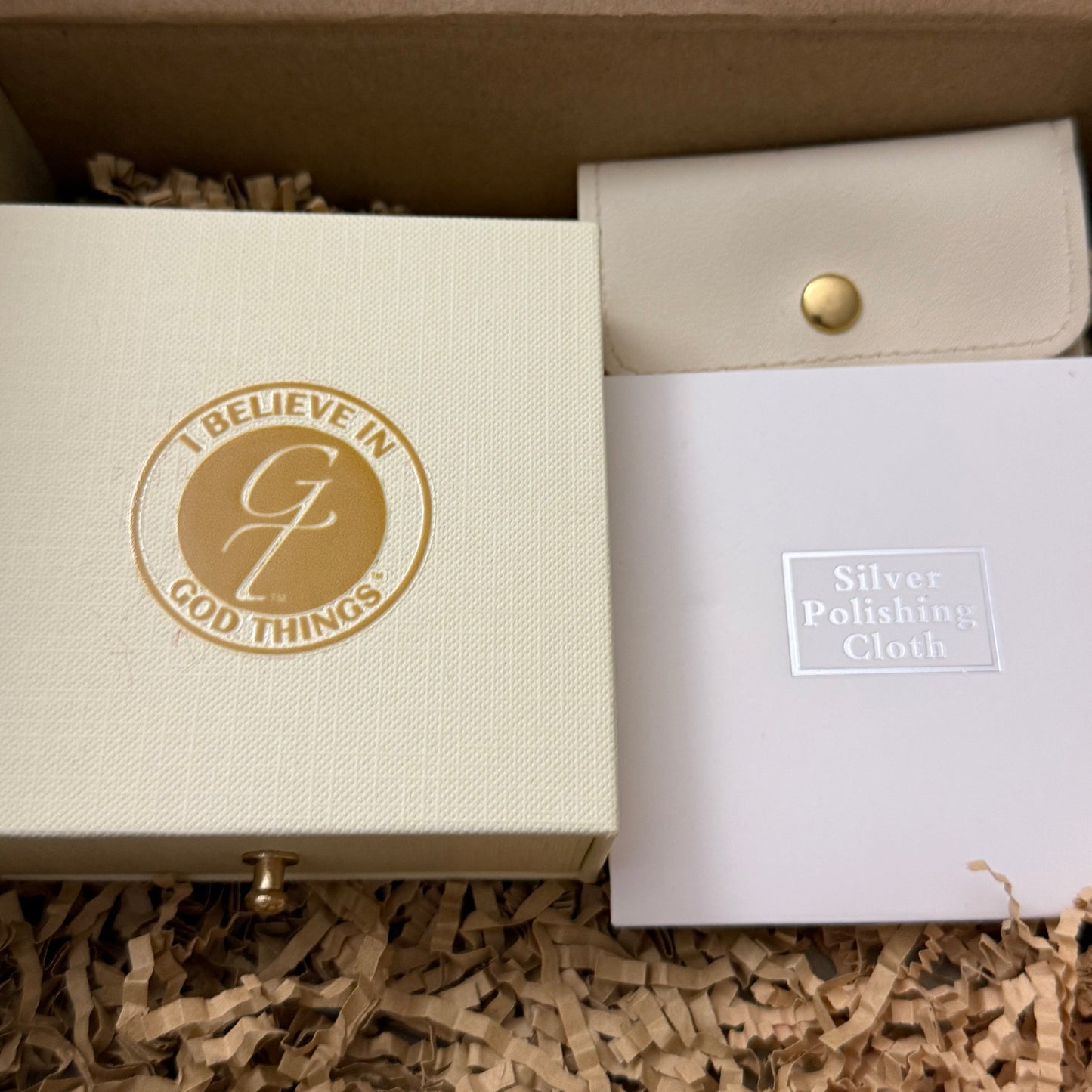 White box with a gold logo and text, placed on a textured surface.