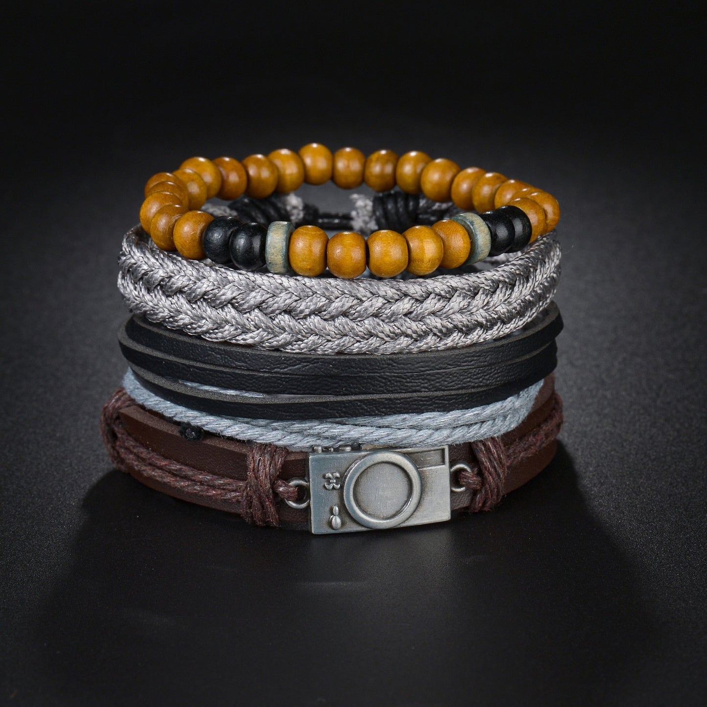 Stack of multi-layered bracelets with beads and leather straps on a dark background