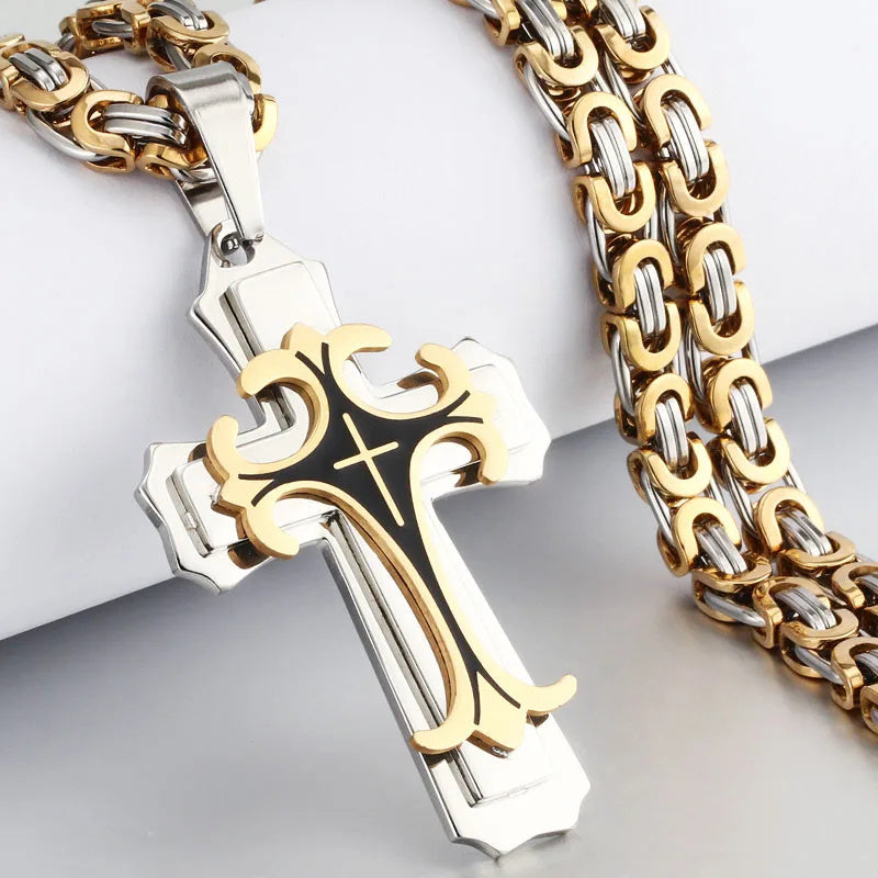 Gold and silver cross pendant with chain on a light gray background